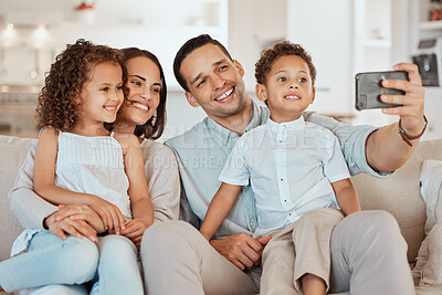 Buy stock photo Shot of a young family taking a selfie at home