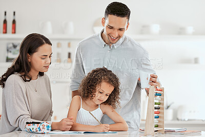 Buy stock photo Shot of young parents helping their daughter with homework at home