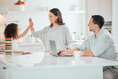 Buy stock photo Shot of a young mother giving her daughter a high five while doing homework at home