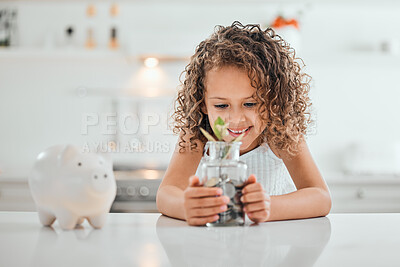 Buy stock photo Shot of a little girl holding a jar filled with coins at home