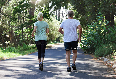 Buy stock photo Senior couple, running and back outdoor for exercise, workout and training on road for fitness. Elderly man and woman together for cardio health and wellness on run in nature forest for retirement