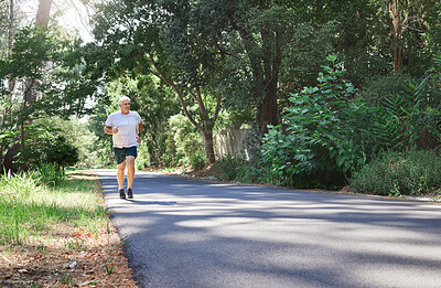 Buy stock photo Man, exercise and outdoor in nature for run, workout and training on road with trees for fitness. Happy senior male person smile and thinking of cardio health and wellness while running in retirement