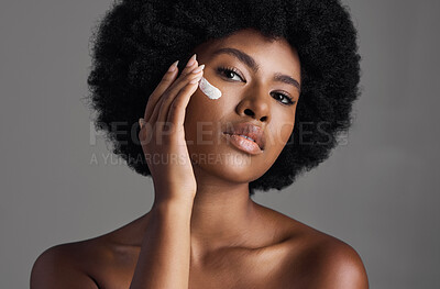 Buy stock photo African woman, face cream and studio portrait with afro, skincare or cosmetic by grey background. Girl, model and healthy with natural glow on skin with makeup, clean aesthetic and product for beauty