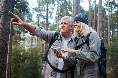 Buy stock photo Senior couple, hiking and phone outdoor in nature for direction for exercise, fitness and trekking. Old man and woman with smartphone and hand on forest hike for workout, cardio and gps or compass
