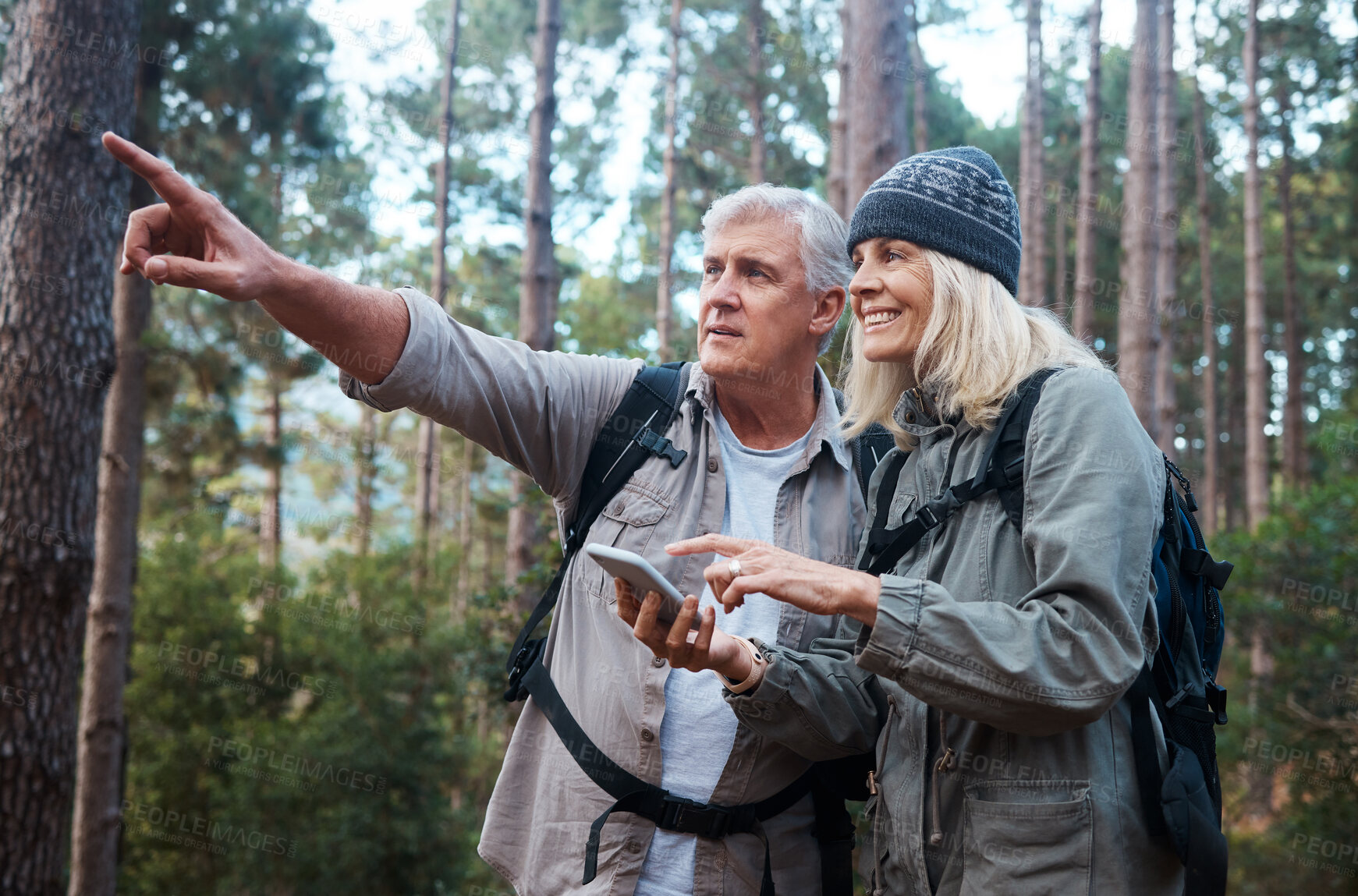 Buy stock photo Senior couple, hiking and phone outdoor in nature for direction for exercise, fitness and trekking. Old man and woman with smartphone and hand on forest hike for workout, cardio and gps or compass