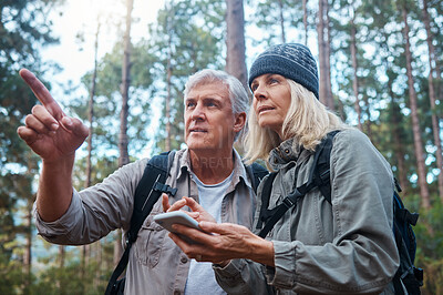 Buy stock photo Hiking, senior couple and phone outdoor in nature for direction for exercise, fitness and trekking. Old man and woman with smartphone pointing on forest hike for workout, cardio and gps or compass