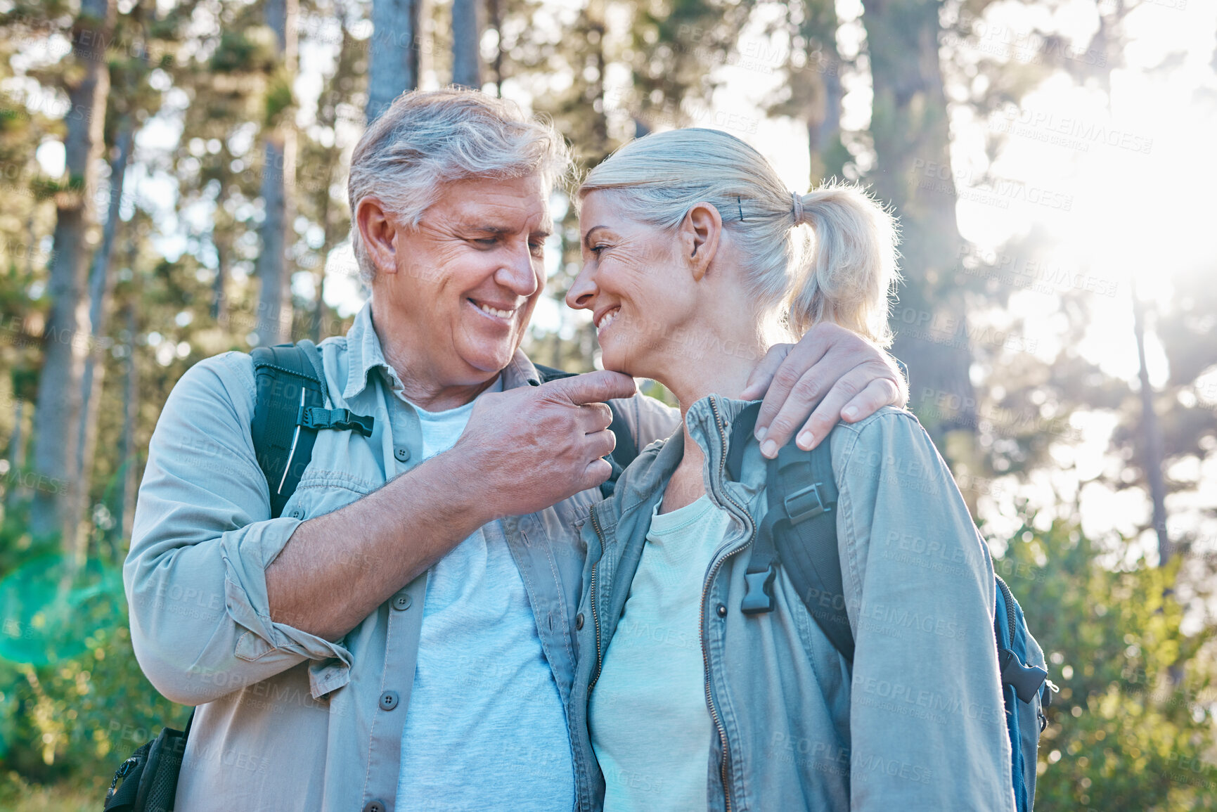 Buy stock photo Love, nature and senior couple on a hike together in a forest while on outdoor weekend trip. Happy, intimate moment and elderly man and woman in retirement trekking in woods to explore and adventure.