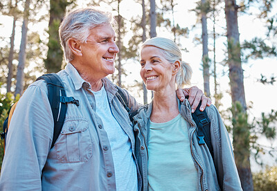 Buy stock photo Senior couple, hiking and happy outdoor in nature for exercise, fitness and trekking for health and wellness. Old man and woman smile and hug on hike in forest for workout, cardio and retirement