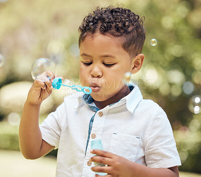 Buy stock photo Child, boy and blowing bubbles in outdoor park for playing, development or activity. Summer, freedom and young kid with soap toy for entertainment, having fun or enjoyment on weekend in backyard