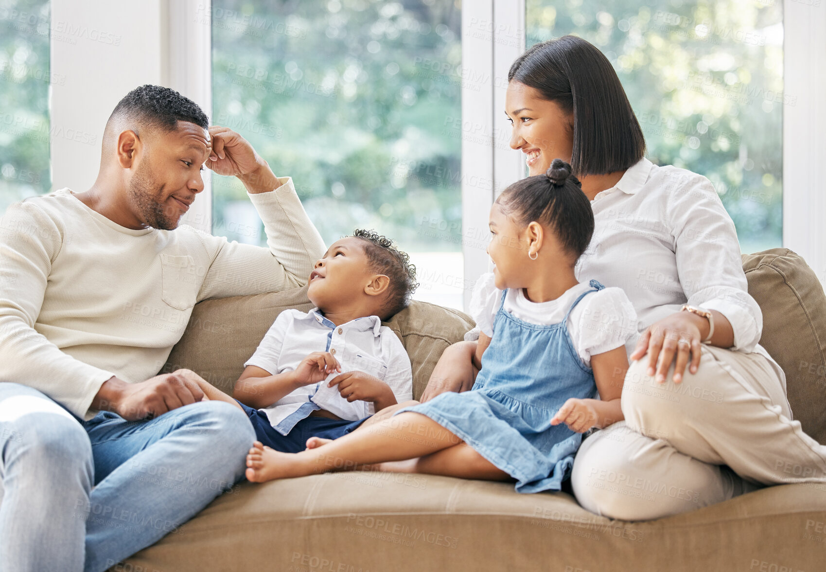 Buy stock photo Parents, kids and happiness with love on sofa for weekend bonding, affection and safety with trust or security. Mother, father and children in home on couch for relax with care, embrace and together.