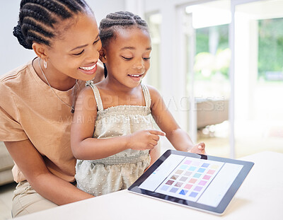 Buy stock photo Shot of an attractive young mother sitting with her daughter and helping her with her motor skills on a digital tablet