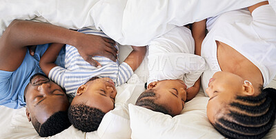 Buy stock photo High angle shot of a young family sleeping in the same bed at home