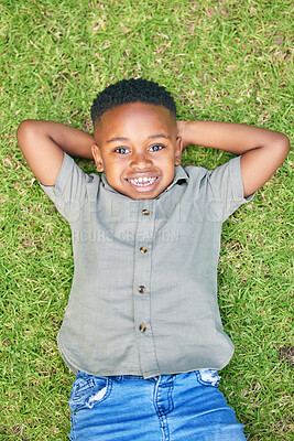 Buy stock photo Shot of a boy laying on the grass outside