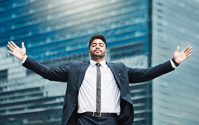 Buy stock photo Cropped shot of a handsome young businessman standing with his arms outstretched in the city