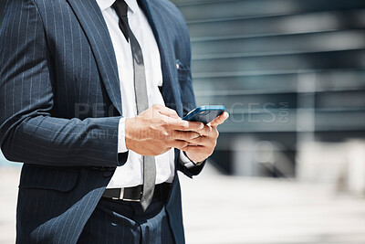 Buy stock photo Cropped shot of an unrecognizable businessman sending a text message while out in the city