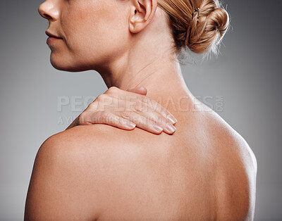 Beautiful mature woman posing in studio against a grey background