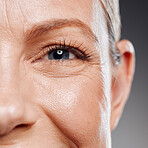 Beautiful mature woman posing in studio against a grey background