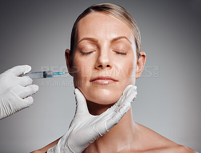 Buy stock photo Beautiful mature woman getting botox injection in studio against a grey background