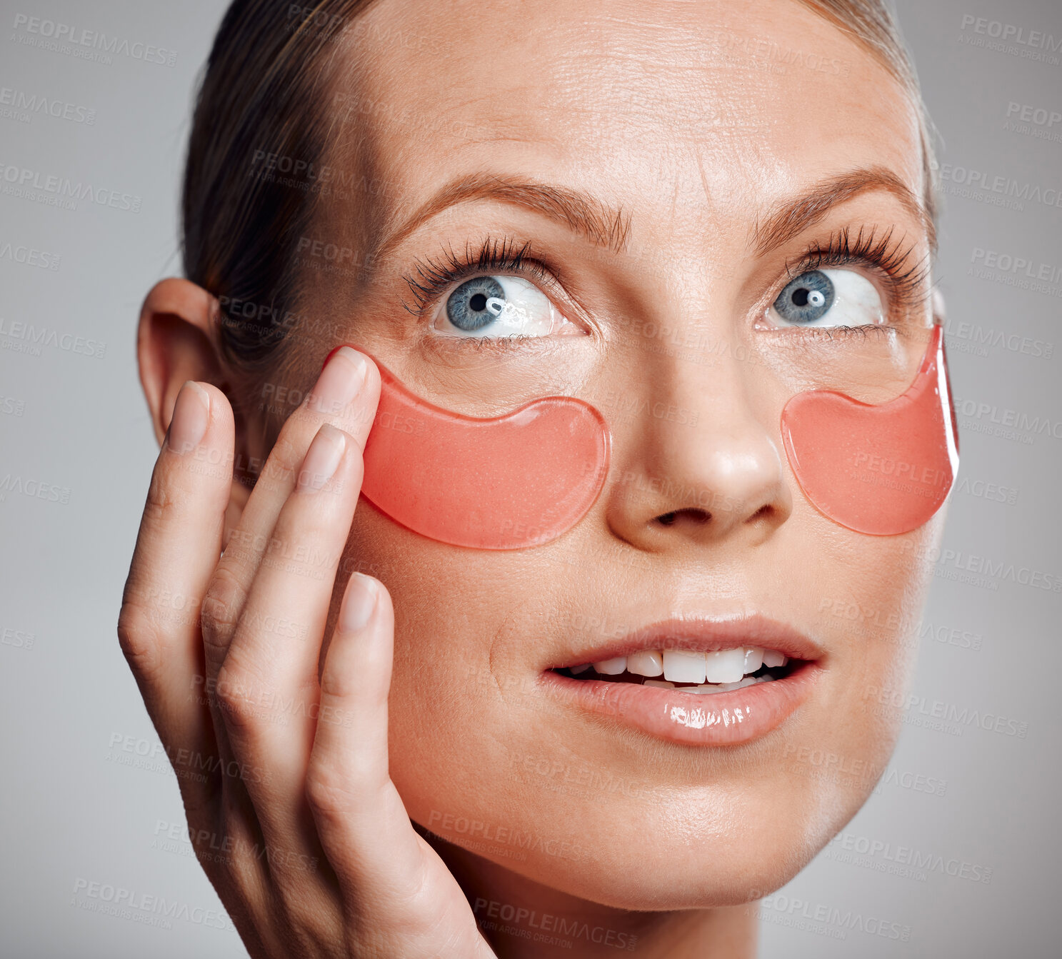 Buy stock photo Beauty, woman and eye patches for skincare, thinking and collagen treatment for wellness. Apply mask, mature model or cosmetics on face for dermatology, glow and anti aging on gray studio background