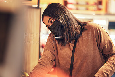 Buy stock photo Shot of a young woman making a phone call while doing her grocery shop
