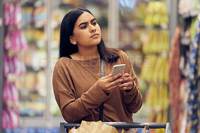 Buy stock photo Choice, shopping and phone with woman in supermarket for grocery, research and cooking app. Product, retail and groceries sale with female customer in store for nutrition, offer and food cost