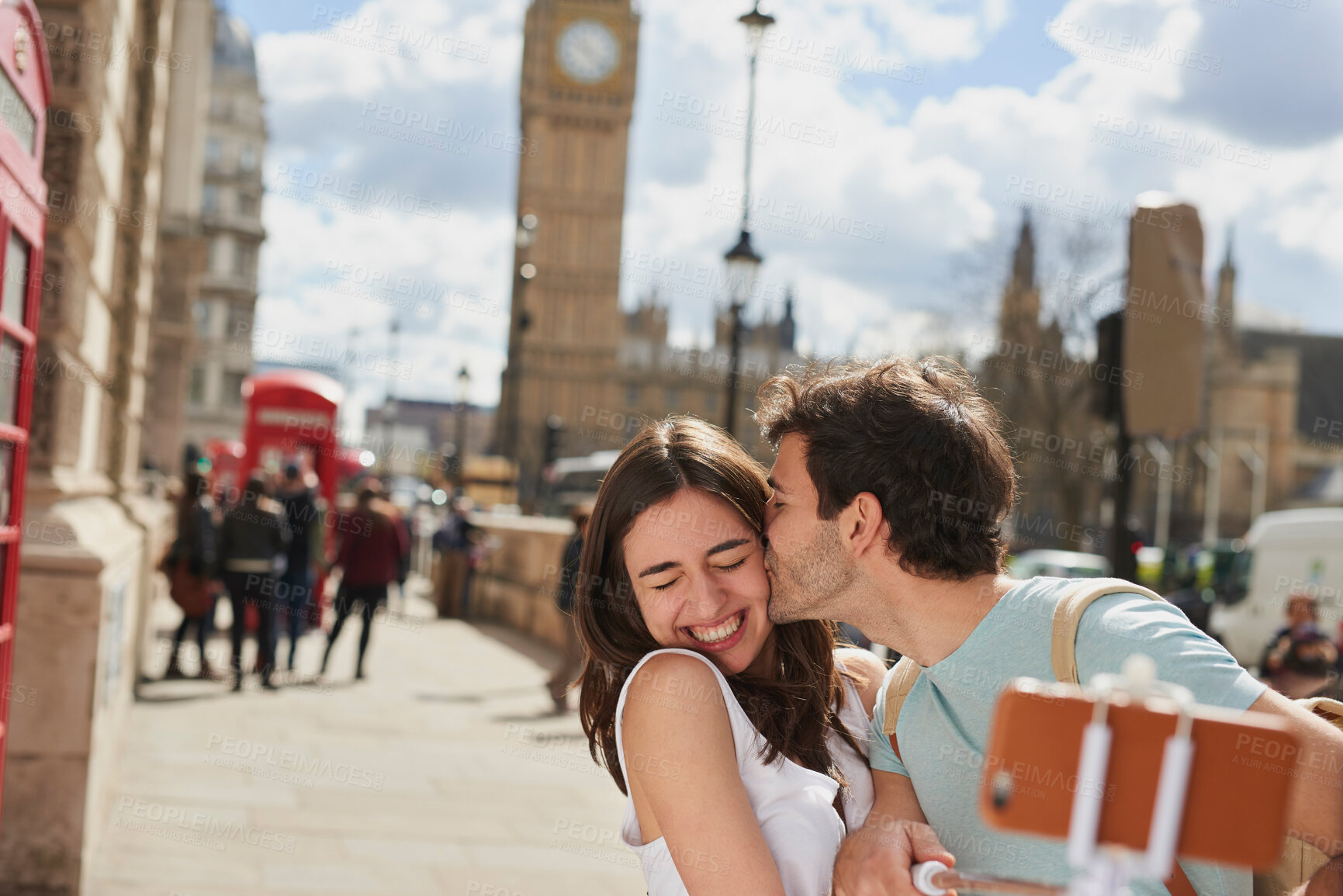 Buy stock photo Couple, travel and selfie with kiss outdoor in London for romantic holiday, adventure and love in city street. Man, woman and smartphone, happiness with smile in traveling photo, tourist and romance.