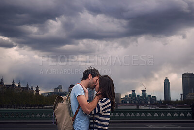 Buy stock photo Love, couple and kiss on city bridge or outdoors in town on vacation, trip or holiday, Cloudy day, romance and affection of man and woman kissing in street, bonding and enjoying quality time together