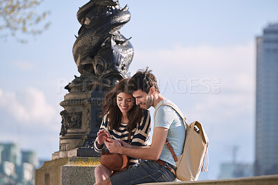 Buy stock photo Couple, phone and travel holiday while at statue doing search on internet for map information on tourist trip. Man and woman with cellphone for social media content on foreign city journey in London