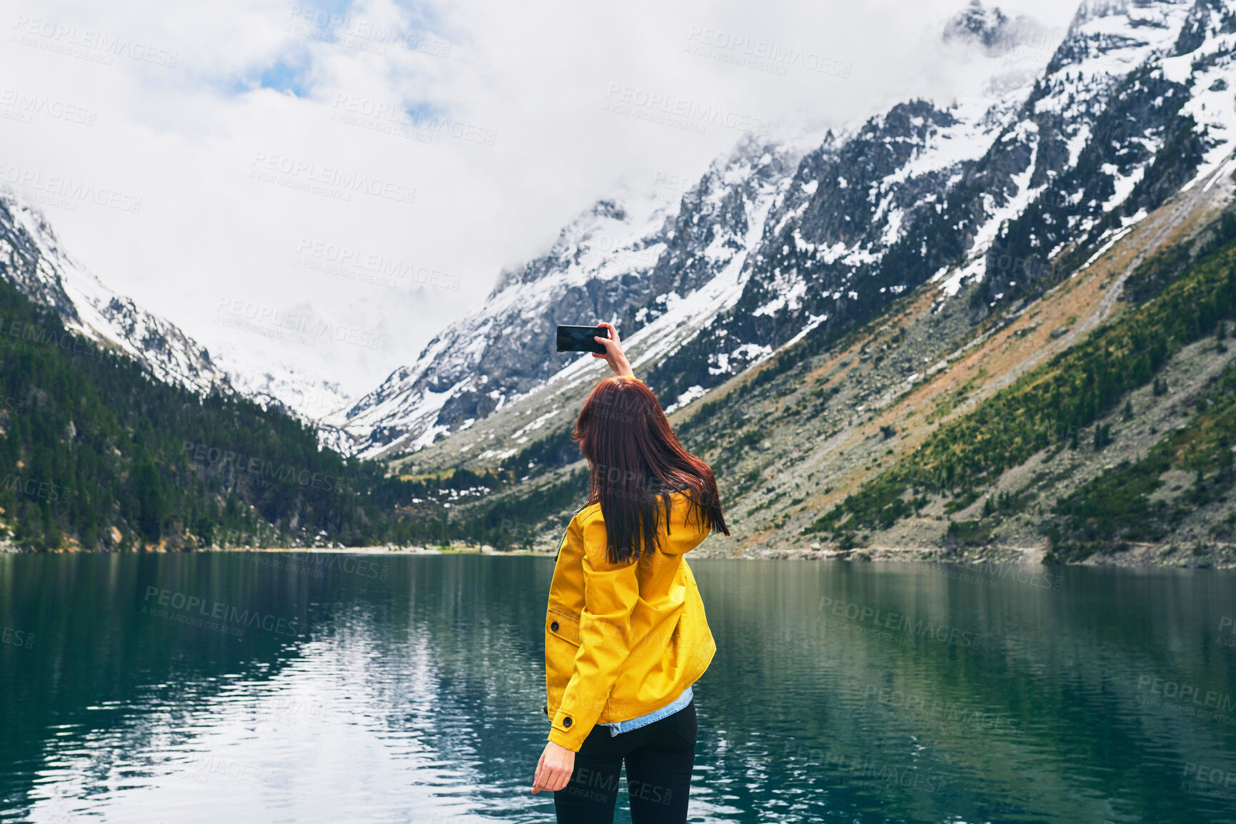 Buy stock photo Lake, photography and back of person, smartphone and tourist on hike, water or picture of adventure. Travel, influencer and mobile for memory, river and view of mountain, holiday or scenery of Canada