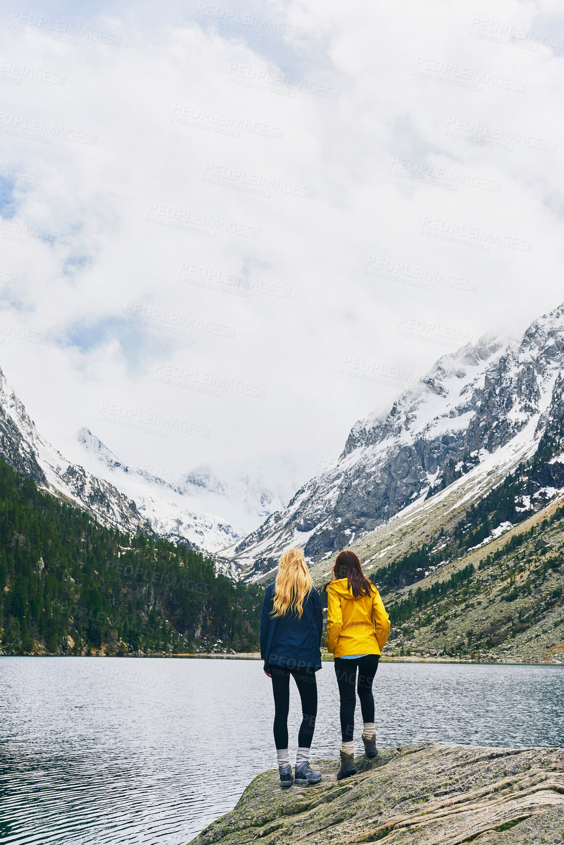 Buy stock photo Women, friends and lake on mountain with snow for winter holiday and adventure in Canada. Back view, tourist and trip in water dam at countryside for hiking, camping and bonding  on break to relax