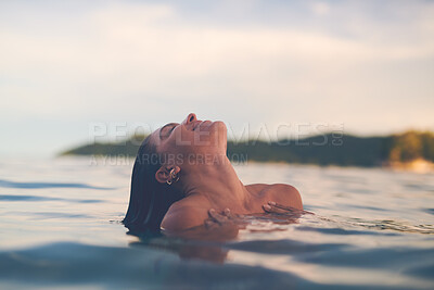 Sexy young woman swimming in the sea. Enjoying a summer vacation and relaxing weekend