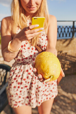 Buy stock photo Phone, social media and woman hands with lemon on holiday with photography and online on vacation. Young female person, mobile and freedom with produce photo in a city outdoor with citrus in Italy