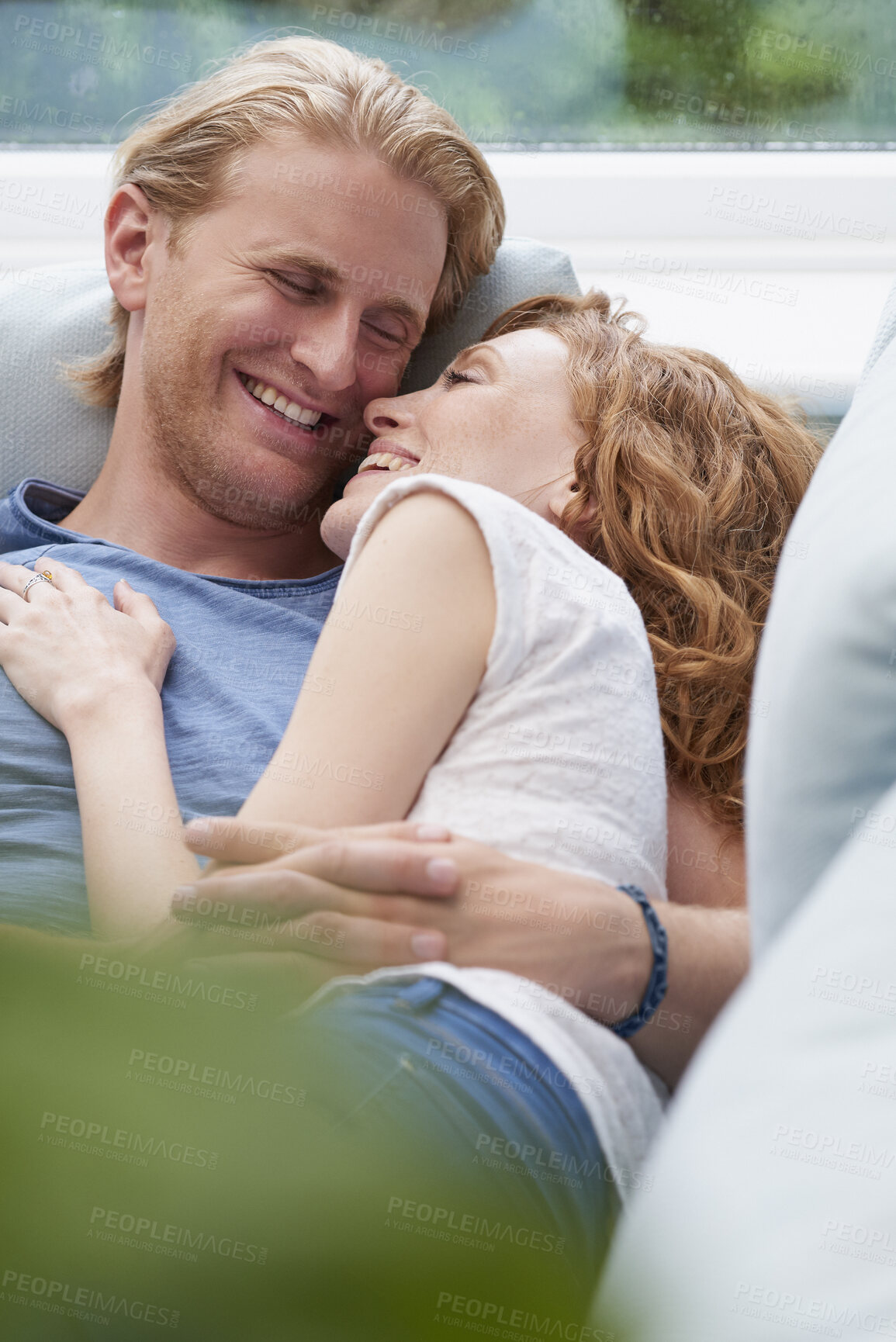 Buy stock photo Relax, laughing or couple on couch to cuddle in home for marriage, commitment or loyalty to partner. Smile, happy or people lying together for support with romance, care or trust for bonding or love