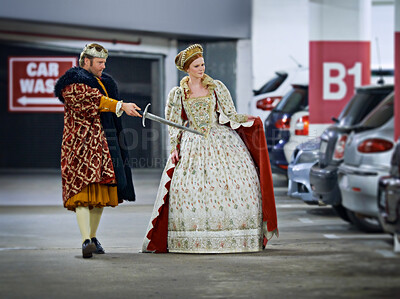 Buy stock photo A king and queen in a parking garage viewing cars suspiciously