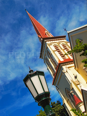 Buy stock photo Architecture, low angle and travel with church in city for religion, Christian holy temple and building. Outdoor, worship and prayer with street lamp in Town for spiritual, catholic and God.