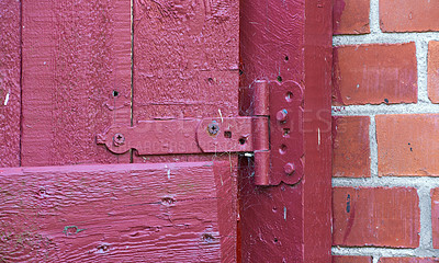 Buy stock photo Closeup, red door and hinge with rusty metal for old exterior, damage or vintage doorframe of abandoned home. Empty, entrance or weathered wood with poor lock for bad maintenance or safety breach