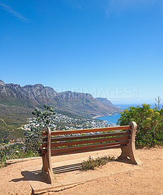 Buy stock photo Bench near a cliff on the mountains with stunning views of the city sea on a blue sky copy space. Landscape of an empty outdoor relaxing seat area with nature scenery in Cape Town, South Africa