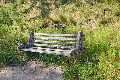 Buy stock photo An old wooden bench in an open field outside. A quiet place to find peace and clear your mind and enjoy the beauty of  nature 