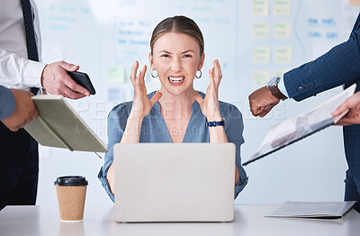 Portrait of stressed businesswoman being nagged by office colleagues. Irritated and angry caucasian professional woman feeling frustrated while using laptop. Coworkers and interns disturbing manager