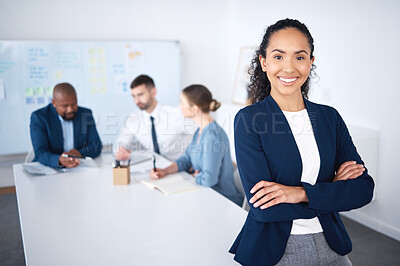 Buy stock photo Portrait of confident smiling mixed race businesswoman leaning on desk in boardroom with arms folded. Diverse group of businesspeople in meeting and working behind happy hispanic manager in an office