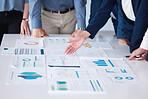 Unknown group of diverse businesspeople using paperwork during a boardroom meeting in an office. Closeup of colleagues standing and planning while using documents to brainstorm a strategy together