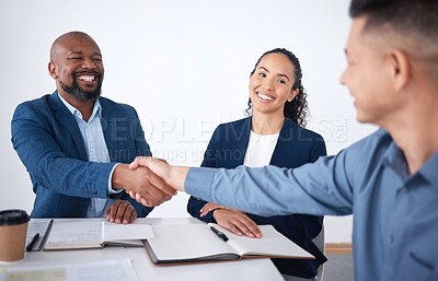 Team of smiling diverse business people shaking hands in office after meeting in boardroom. Group of happy professionals and colleagues using handshake and gesture to congratulate success and welcome