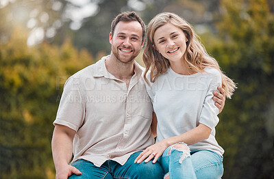 Young happy loving caucasian couple hugging and enjoying a day together in a park on the weekend. Two cheerful young people relaxing together in nature