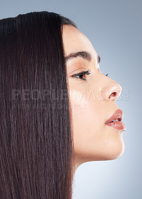 Close up profile of a beautiful brown-haired woman with perfectly smooth hair and natural make-up
