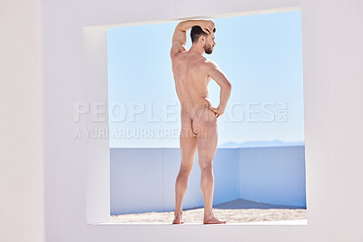 Buy stock photo One handsome nude caucasian man framed from the back posing naked and looking at the view against a blue sky outside. Sexy young sensual and seductive male model flaunting muscular toned body and ass