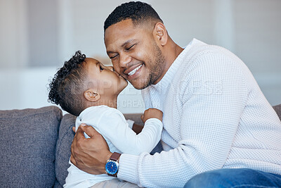Adorable little boy kissing his dad on the cheek. African american man laughing with his eyes closed while receiving love and affection from his son. Man being spoiled on father\'s day