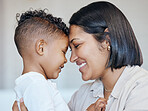 Cute little boy and mom touching foreheads. Closeup of happy mother and son looking into each other's eyes. Mixed race family expressing love and support, enjoying tender moment together at home