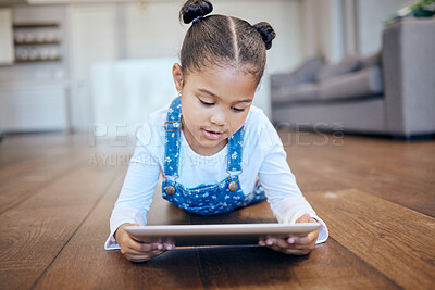 Buy stock photo Kid, little girl and tablet for streaming in home with internet for entertainment, learning or watching. Child, youth and lying on floor in living room with technology for online, cartoon or game