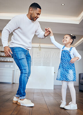 Handsome mixed race father dancing at home with his little girl. Happy dad and daughter sharing a dance and having fun together at home