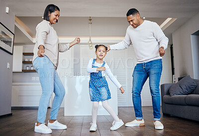 Buy stock photo Dance, love and freedom with an interracial family having fun in the living room of their home together. Energy, smile or happy with a mother, father and excited daughter moving in their apartment